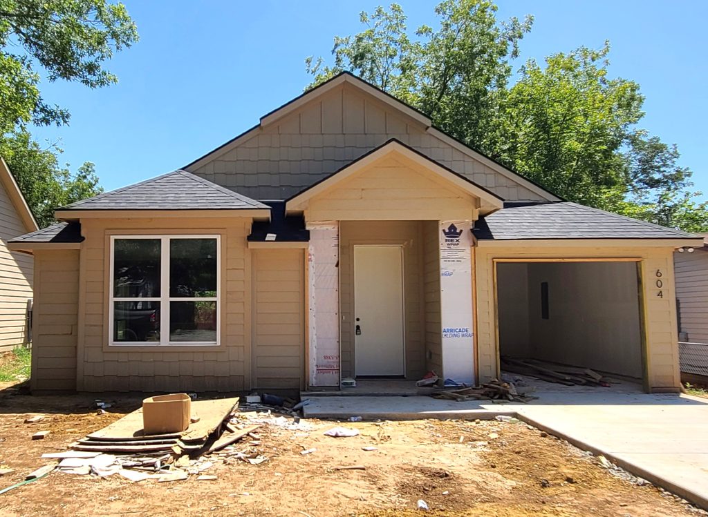Front of an entry level home located in Denison, near Lake Texoma with a one car garage