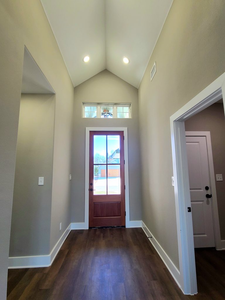 Vaulted ceiling foyer with large front door in Tom Bean, Texas